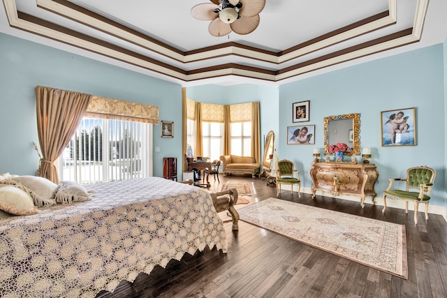 bedroom featuring ornamental molding, hardwood / wood-style floors, access to exterior, and a tray ceiling