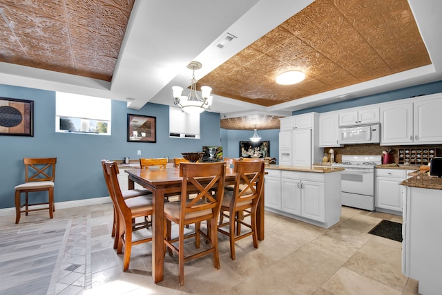 dining area featuring a chandelier and a tray ceiling