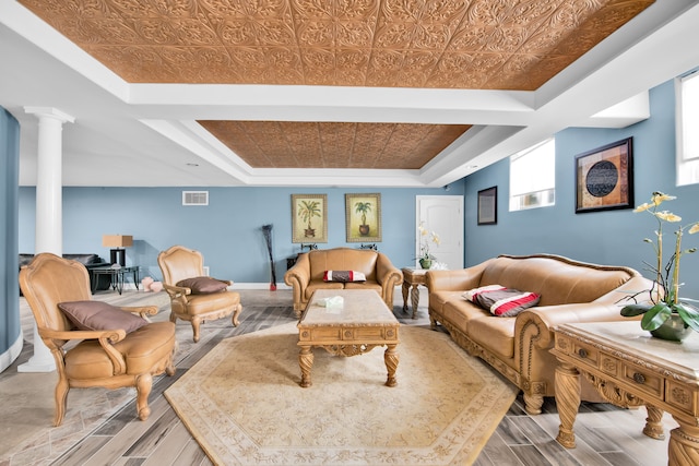 interior space with a raised ceiling and ornate columns