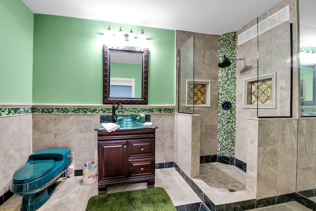 bathroom with a tile shower, vanity, and tile walls