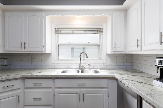 kitchen with sink, white cabinets, and backsplash