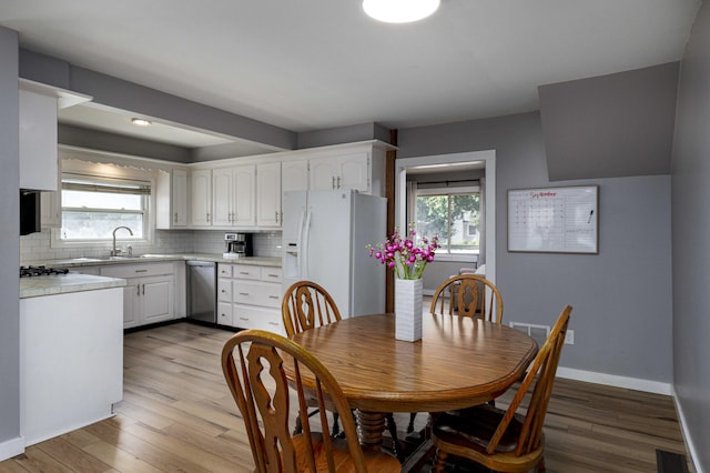 dining area featuring plenty of natural light, light hardwood / wood-style floors, and sink