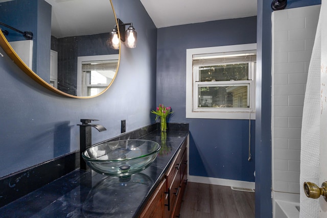 bathroom featuring shower / bath combination with curtain, a healthy amount of sunlight, wood-type flooring, and vanity