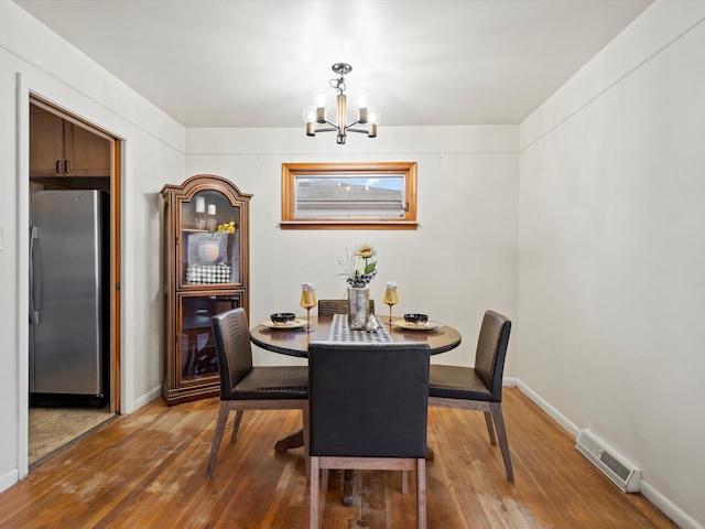 dining space featuring hardwood / wood-style floors and a chandelier