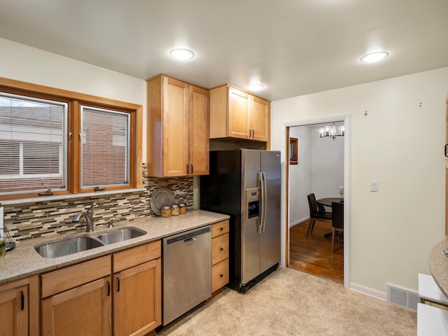 kitchen featuring sink, appliances with stainless steel finishes, decorative backsplash, light colored carpet, and a chandelier