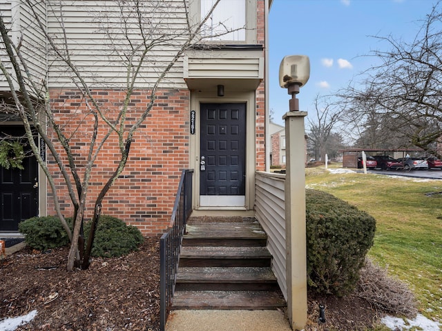 property entrance with a lawn