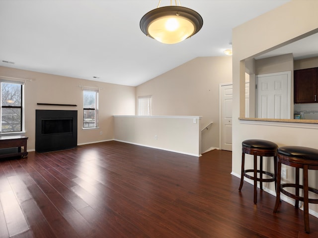 living room with dark hardwood / wood-style floors and vaulted ceiling