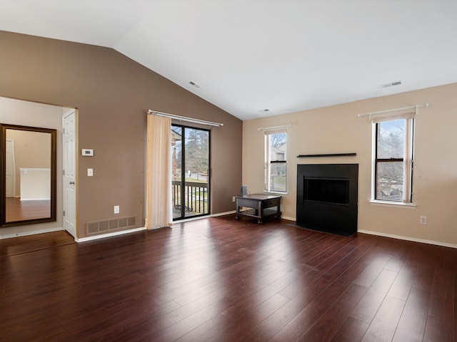 unfurnished living room featuring lofted ceiling, plenty of natural light, and dark hardwood / wood-style floors