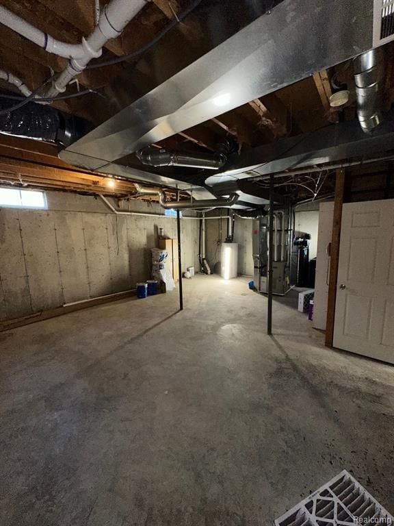 basement featuring water heater and heating unit