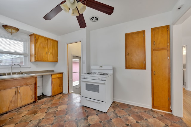 kitchen featuring ceiling fan, sink, and gas range gas stove