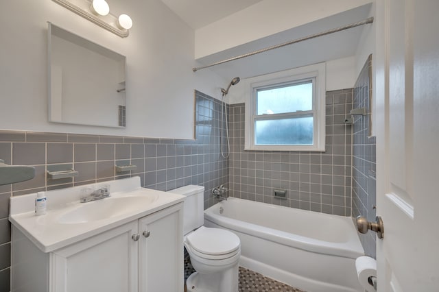 full bathroom featuring tile walls, vanity, toilet, and tiled shower / bath