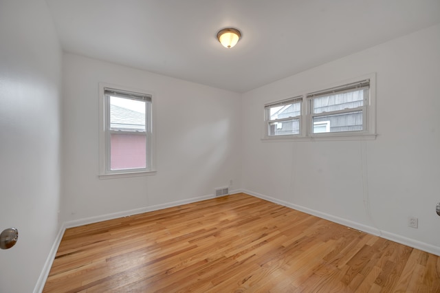 spare room featuring plenty of natural light and light hardwood / wood-style floors