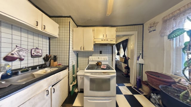 kitchen with cream cabinets, sink, decorative backsplash, and electric stove