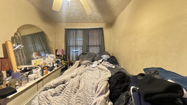 bedroom with ceiling fan and a textured ceiling