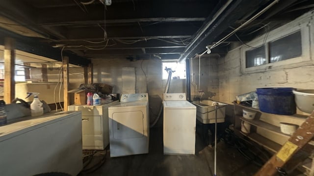 basement featuring fridge, sink, and independent washer and dryer