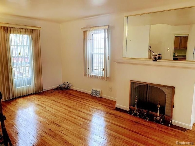 unfurnished living room with light hardwood / wood-style flooring and a wealth of natural light