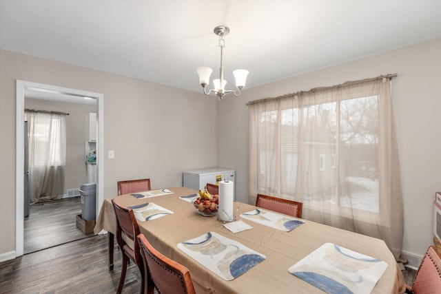 dining area featuring an inviting chandelier and dark wood-type flooring