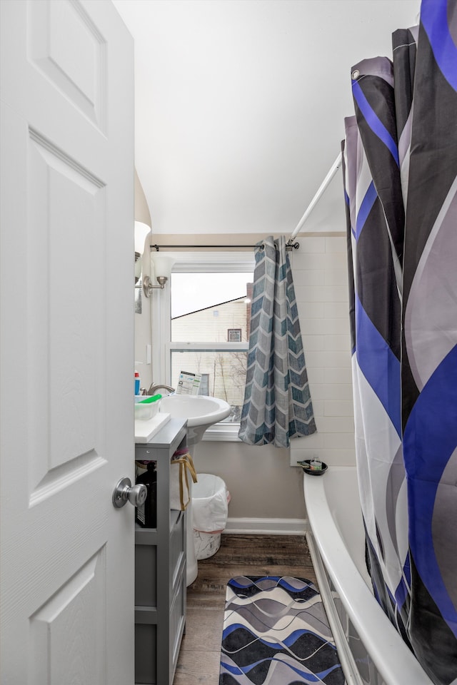 bathroom with shower / bath combination with curtain, vaulted ceiling, sink, and hardwood / wood-style flooring