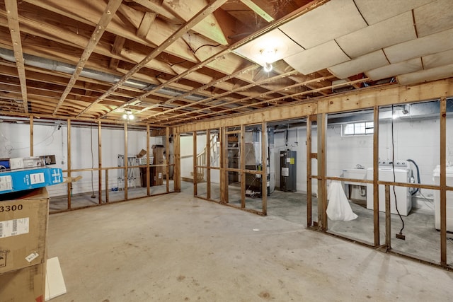 basement featuring washing machine and dryer and electric water heater