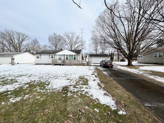 view of front facade featuring an outbuilding, a wooden deck, and a garage