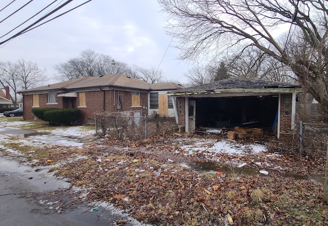 view of side of property featuring brick siding, an outbuilding, and fence