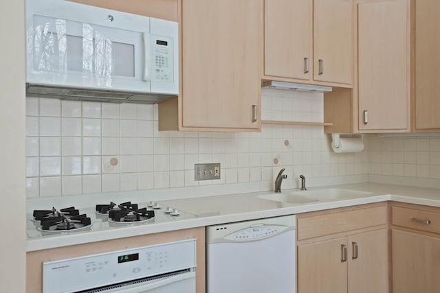 kitchen featuring sink, white appliances, decorative backsplash, and light brown cabinets