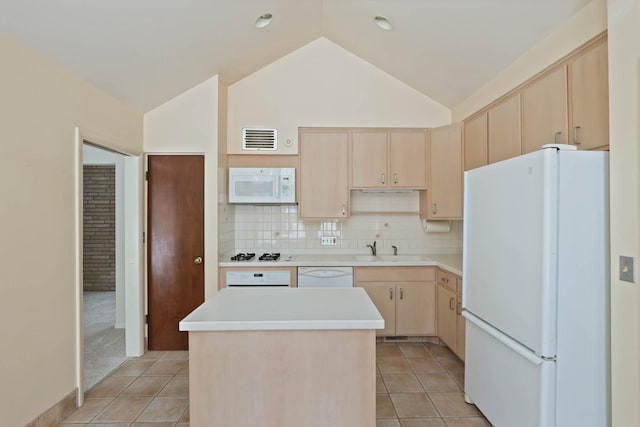 kitchen featuring light brown cabinetry, white appliances, and a kitchen island