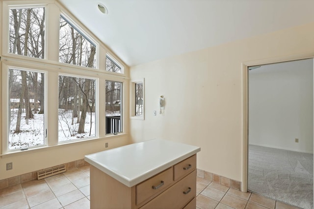 kitchen featuring high vaulted ceiling, light tile patterned flooring, and a kitchen island