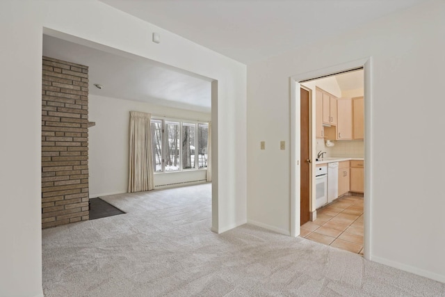 hall with light tile patterned floors and light carpet