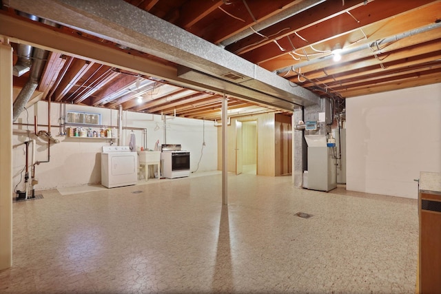 unfinished basement featuring separate washer and dryer, heating unit, a sink, and visible vents