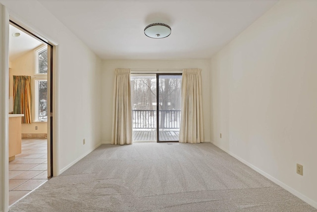 carpeted empty room featuring baseboards