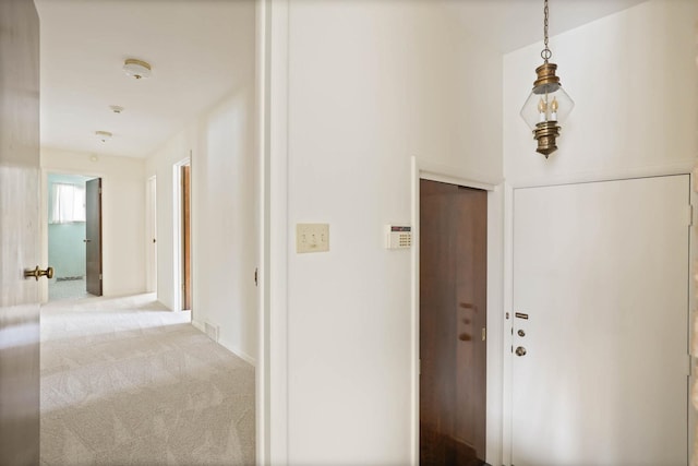 hallway featuring light colored carpet