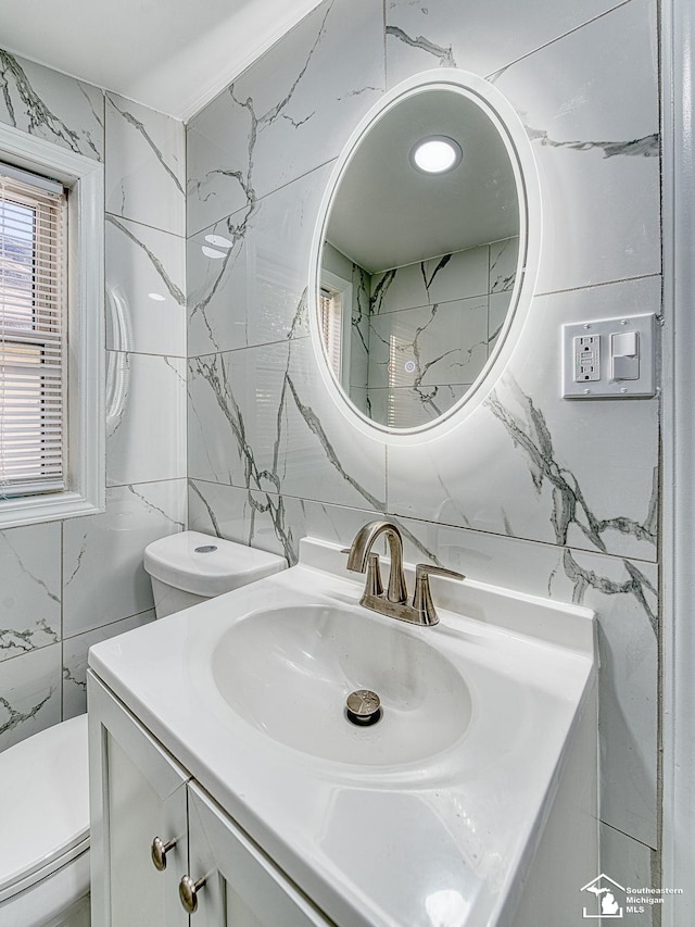 bathroom featuring a baseboard radiator, vanity, toilet, and tile walls