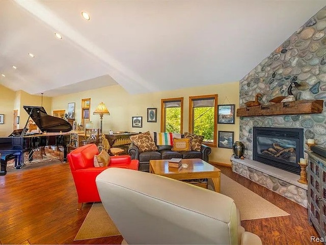 living room with lofted ceiling, a fireplace, and hardwood / wood-style floors