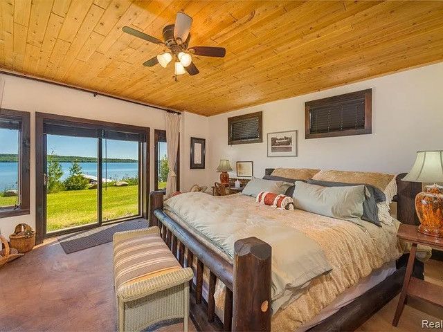 bedroom with a water view, ceiling fan, carpet, and wooden ceiling