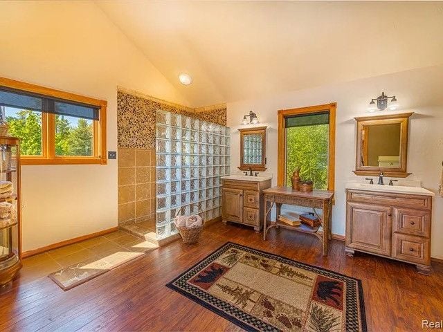 bathroom featuring vanity, hardwood / wood-style floors, and high vaulted ceiling