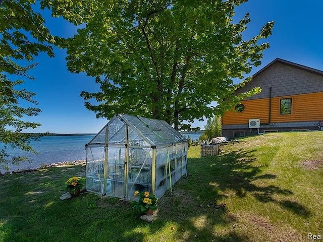 view of outdoor structure with a water view and a yard