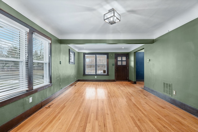 unfurnished living room featuring a healthy amount of sunlight and light hardwood / wood-style floors