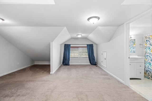 additional living space featuring carpet flooring and vaulted ceiling with skylight