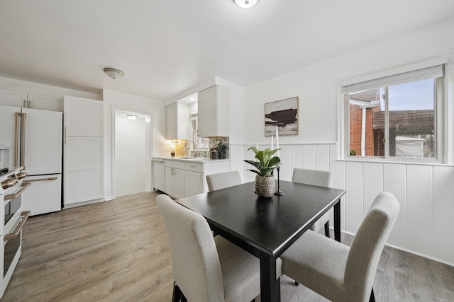 dining area with sink and light hardwood / wood-style flooring