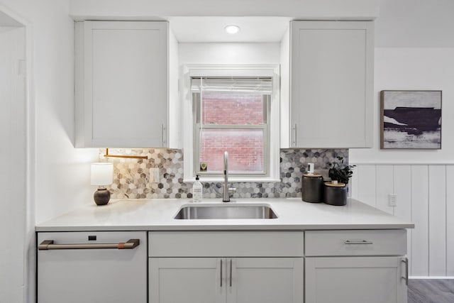 kitchen with tasteful backsplash, sink, white cabinetry, and dishwasher