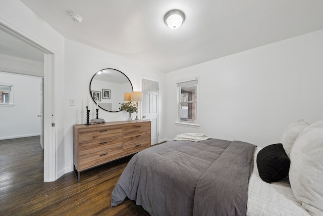 bedroom with multiple windows and dark hardwood / wood-style flooring