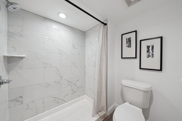 bathroom featuring toilet and curtained shower