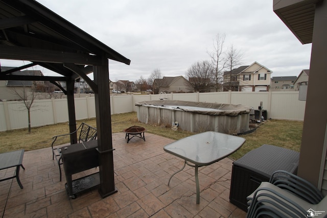 view of patio / terrace with a gazebo, a covered pool, and an outdoor fire pit