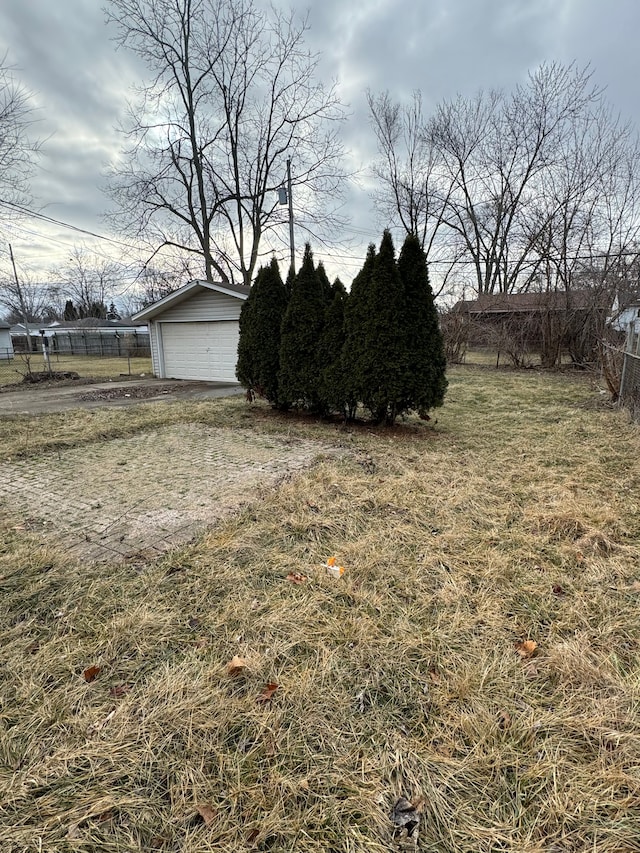 view of yard featuring a garage, an outdoor structure, and a rural view