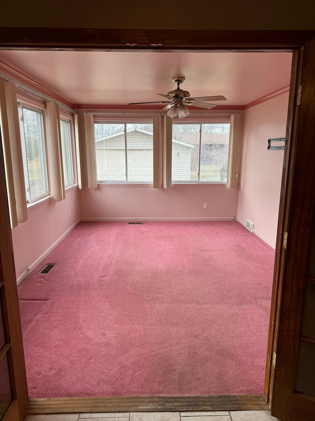 empty room with ceiling fan, ornamental molding, and light carpet