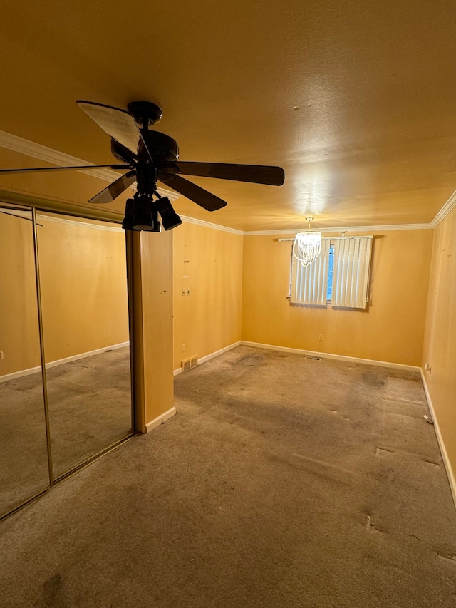 basement featuring ornamental molding, carpet floors, and ceiling fan with notable chandelier