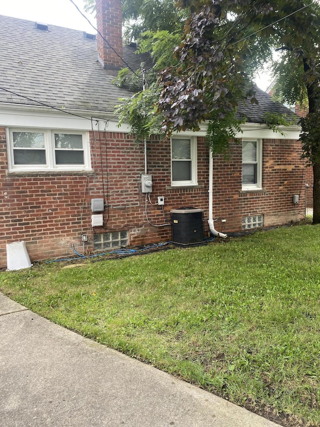 view of property exterior with central AC and a yard