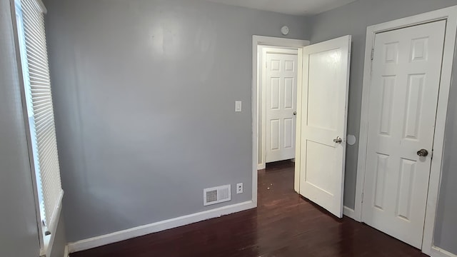 unfurnished bedroom featuring dark hardwood / wood-style floors