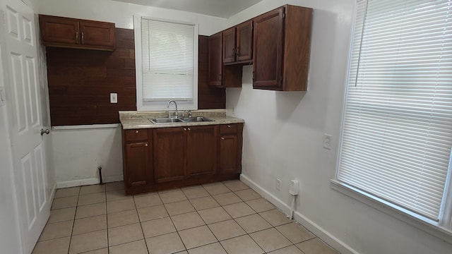 kitchen featuring light tile patterned floors, sink, dark brown cabinets, and a healthy amount of sunlight